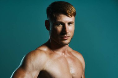 Vücudu kaslı, yeşil arka planı olan atletik bir adam.