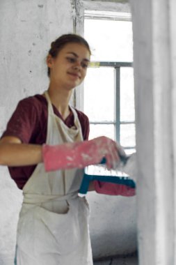 Beyaz önlüklü ev dekorasyonu yapan kadın ressam.