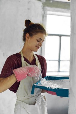 Beyaz önlüklü ev dekorasyonu yapan kadın ressam.