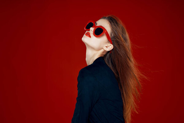 pretty woman wearing sunglasses fashion posing hairstyle red background