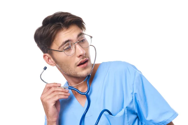 Médico masculino usando gafas estetoscopio posando fondo claro — Foto de Stock