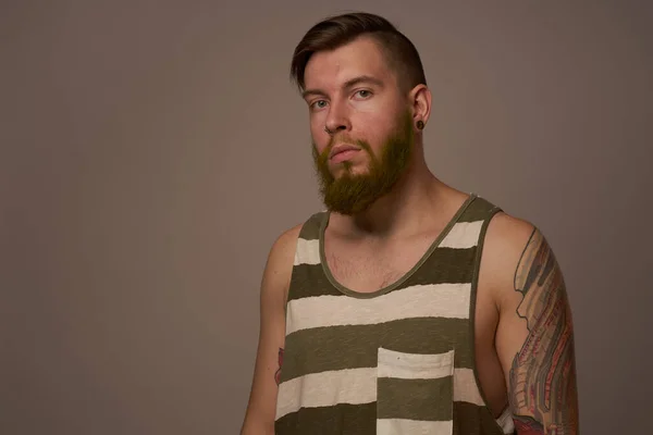Modny mężczyzna z tatuażami na ramionach stylowa fryzura self-confidence studio — Zdjęcie stockowe