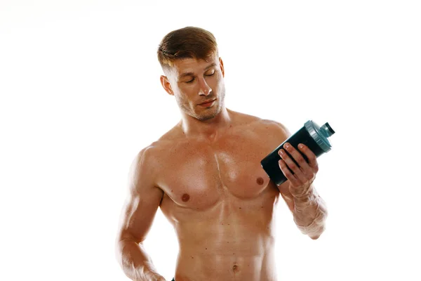 A man an athlete with a pumped-up body drinks from a bottle — Stock Photo, Image