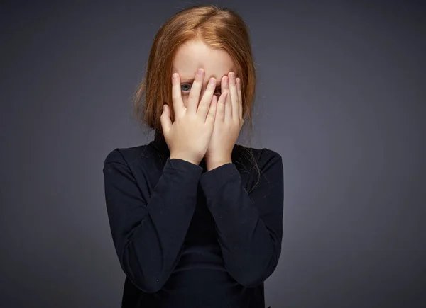 Red-haired girl with freckles on her face in a black sweater posing — Stock Photo, Image