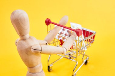 Tahta kukla, sarı arka planda.