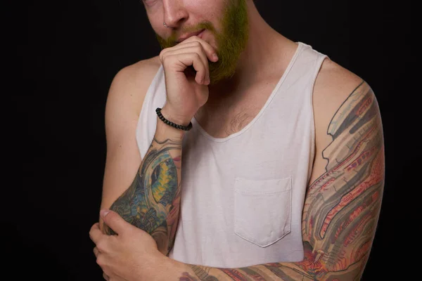 Hombre barbudo con tatuajes en los brazos haciendo gestos con las manos fondo oscuro — Foto de Stock
