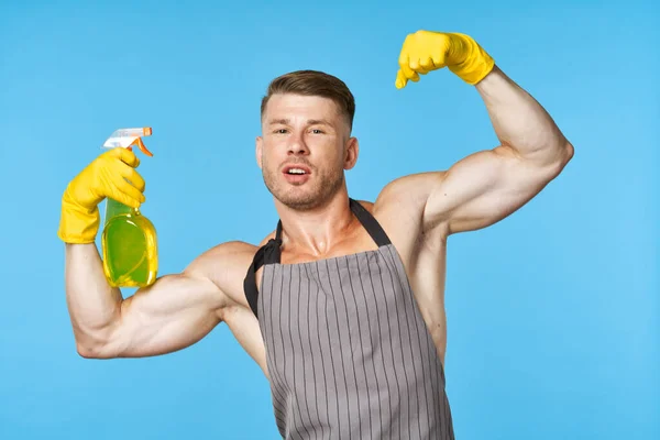 Man met een schort schoonmaakmiddel huishoudelijk werk — Stockfoto