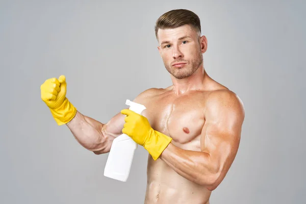 Hombre con músculos bombeados detergente posando limpieza — Foto de Stock