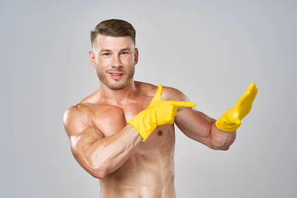 Mann mit aufgepumptem nackten Körper in Gummihandschuhen gestikuliert mit den Händen — Stockfoto