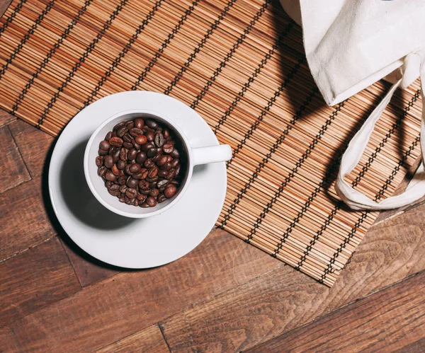 Чашку кофе Горячий напиток пролитой зерна деревянный стол — стоковое фото