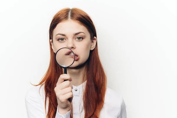 Jolie femme grimacant avec loupe près du visage — Photo