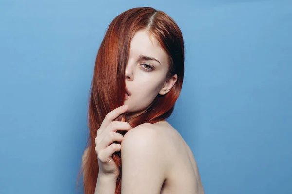 Привлекательная женщина с голыми плечами рыжие волосы крупным планом синий фон — стоковое фото