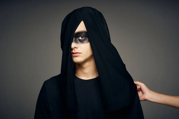 Um homem com uma máscara preta Halloween traje fantasma fundo escuro — Fotografia de Stock