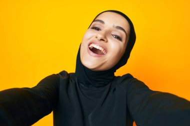 Siyah tesettürlü neşeli kadın moda el hareketi yapıyor izole edilmiş arka plan