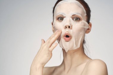 Güzel bir kadın çıplak omuzlarıyla maske takar.