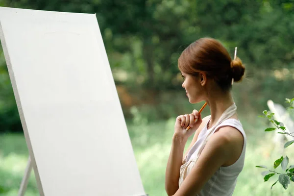 Woman outdoors painting a picture easel art hobby — Stock Photo, Image