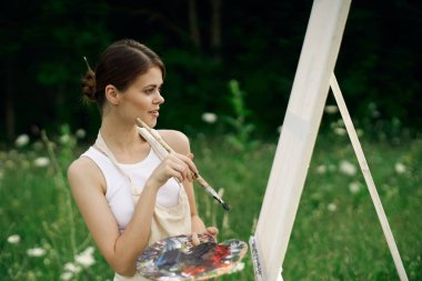 Kadın açık havada resim çiziyor yaratıcılık üzerine bir hobi.