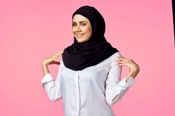 Muslim kvinna med miniräknare och ekonomi pengar rosa bakgrund — Stockfoto