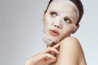 Çıplak omuzlu kadın maske takıyor.