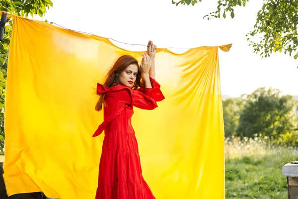 Vacker kvinna i röd klänning gestikulerande med händerna natur gul bakgrund — Stockfoto