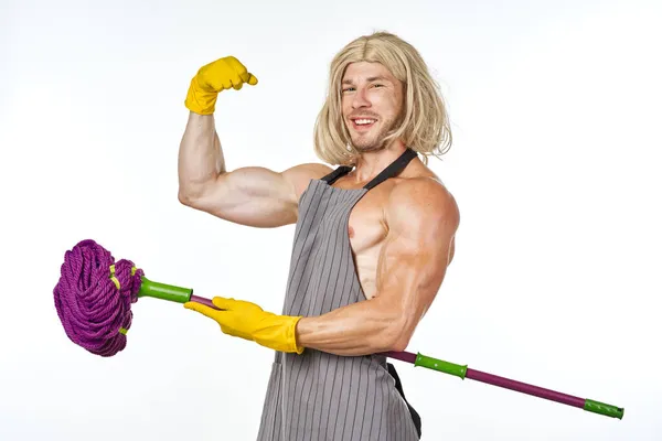 Muskulöser Mann in Schürze mit Wischmopp in Damenperücke — Stockfoto