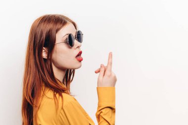 Sarı gözlüklü şık kadın poz veriyor.