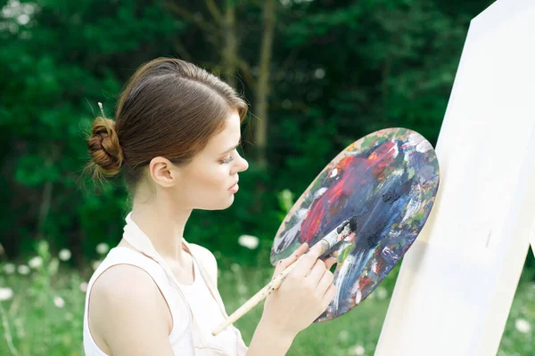 Kobieta artysta maluje paletę sztalugi natura rysunek — Zdjęcie stockowe