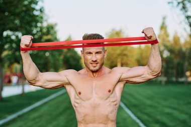 Parkın spor salonunda şişkin vücutlu atletik bir adam.