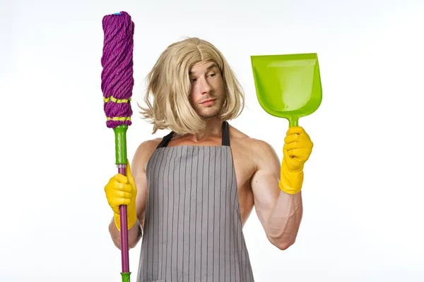 A man in aprons in a womans wig with a mop cleaning — Stock Photo, Image