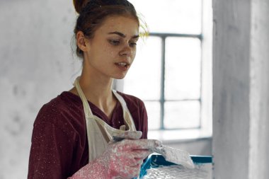 Oda dekorasyonunda fırça boyalı kadın ressam.