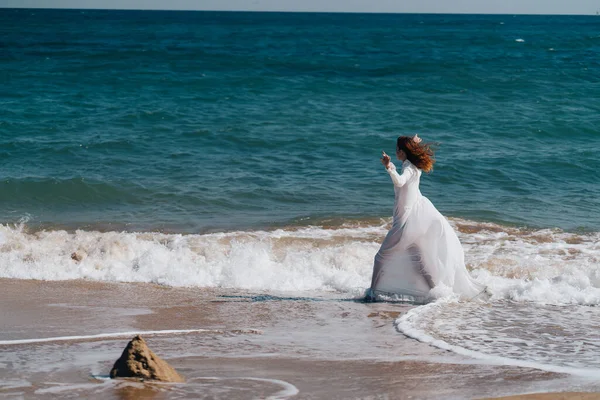 Žena v bílých šatech svoboda chůze na ostrově oceánu — Stock fotografie