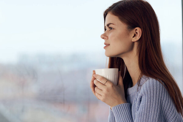 pretty woman dreamy look near window at home rest