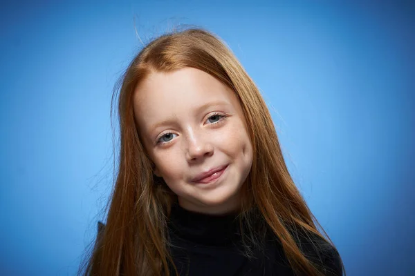 Rödhårig flicka med fräknar i ansiktet poserar närbild blå bakgrund — Stockfoto