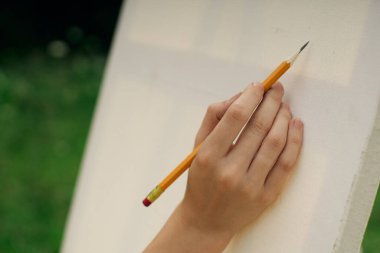 Kalem sehpası çizen kadın eli.