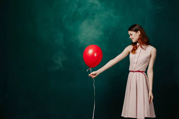 Mulher com balão vermelho no fundo verde férias diversão — Fotografia de Stock