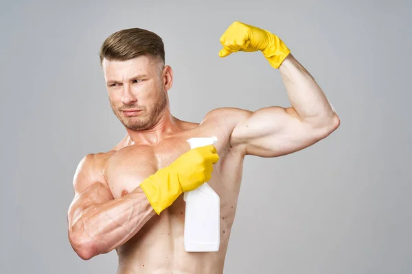 Hombre con músculos bombeados detergente posando limpieza —  Fotos de Stock