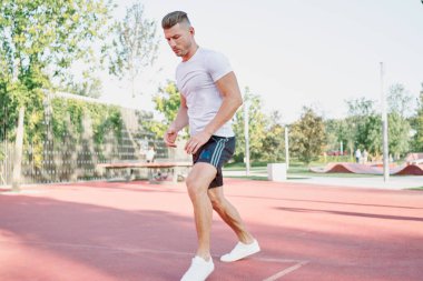 Adam dışarıda oyun sahasında egzersiz yapıyor.