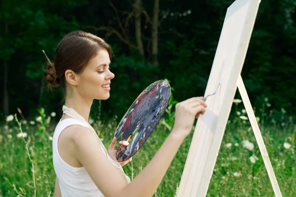 Женщина в белом платье с палитрой красок на рисунке природы — стоковое фото