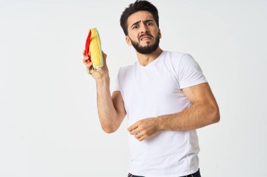 Elinde sebzelerle sakallı bir adam. Sıcak biberli mısır.