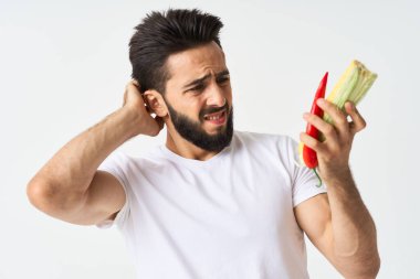 Elinde sebzelerle sakallı bir adam. Sıcak biberli mısır.