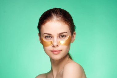 Güzel kadın çıplak omuzlar altın yüz bantları kozmetik