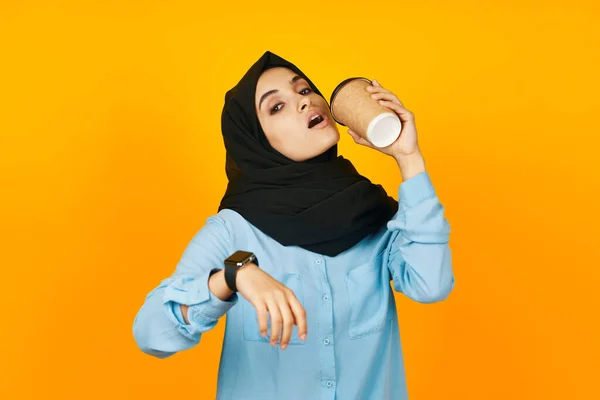 Musulmano un bicchiere di caffè nelle mani di un orologio sfondo isolato — Foto Stock