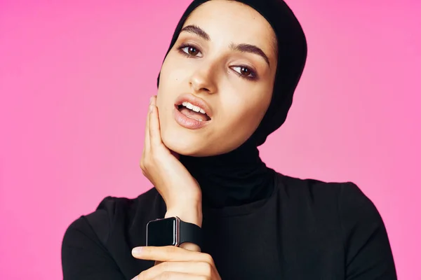 Мусульманка с технологией умных часов гаджет розовый фон — стоковое фото