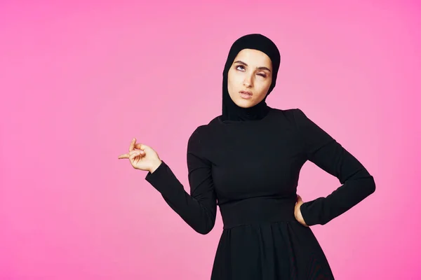 Mulher muçulmana alegre no preto hijab posando moda rosa fundo — Fotografia de Stock