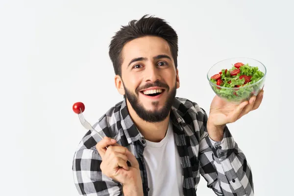 Emocionální vousatý muž v kostkované košili talíř se salátem — Stock fotografie
