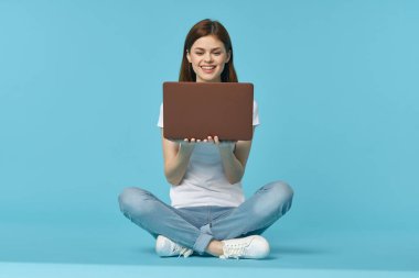 Dizüstü bilgisayarı olan kadın internet eğitimi mavi arka plan