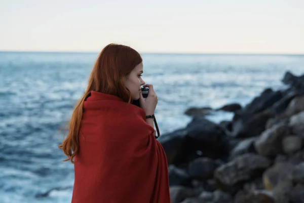 Frau versteckt sich mit einer Decke in der Natur mit einer Kamera Urlaubsfotograf Reise — Stockfoto
