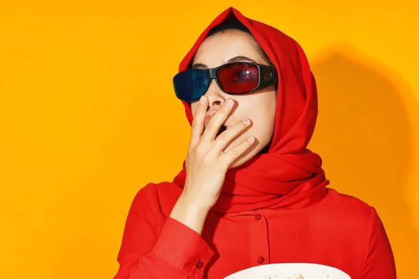 Kvinna i röd hijab 3D-glasögon teknik titta på film popcorn gul bakgrund — Stockfoto
