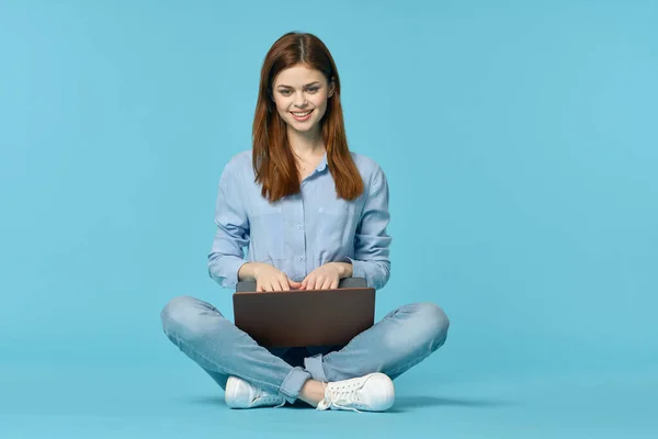 Mujer con portátil aprendizaje internet educación en línea fondo azul — Foto de Stock