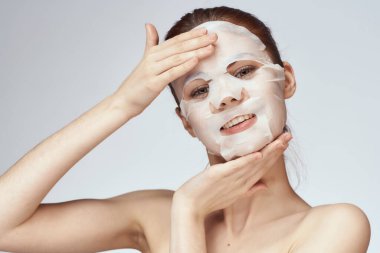 Güzel bir kadın çıplak omuzlarıyla maske takar.